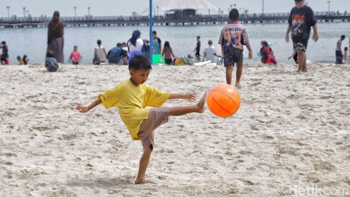 Wisatawan memadati kawasan Pantai Ancol pada Minggu (22/3/2026), memanfaatkan momen libur Idul Fitri untuk bersantai bersama keluarga.