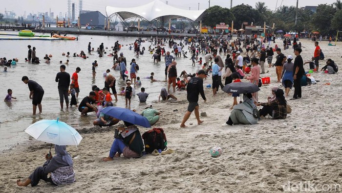 Wisatawan memadati kawasan Pantai Ancol pada Minggu (22/3/2026), memanfaatkan momen libur Idul Fitri untuk bersantai bersama keluarga.