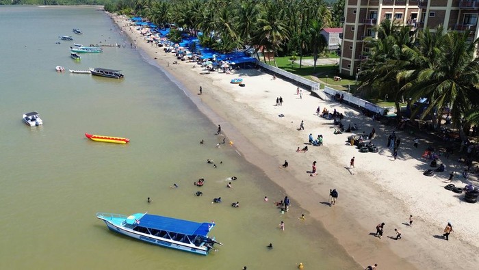 Wisatawan menikmati keindahan pantai saat libur Lebaran 1447 Hijriah di Pantai Pandan, Kabupaten Tapanuli Tengah, Sumatera Utara, Minggu (22/3/2026). Objek wisata Pantai Pandan Tapanuli Tengah mulai dikunjungi wisata lokal dan mancanegara di tengah upaya pemulihan daerah itu yang terkena bencana longsor dan banjir bandang pada akhir November 2025. ANTARA FOTO/Yudi Manar/nym.
