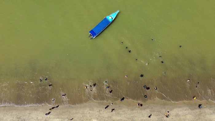 Wisatawan menikmati keindahan pantai saat libur Lebaran 1447 Hijriah di Pantai Pandan, Kabupaten Tapanuli Tengah, Sumatera Utara, Minggu (22/3/2026). Objek wisata Pantai Pandan Tapanuli Tengah mulai dikunjungi wisata lokal dan mancanegara di tengah upaya pemulihan daerah itu yang terkena bencana longsor dan banjir bandang pada akhir November 2025. ANTARA FOTO/Yudi Manar/nym.