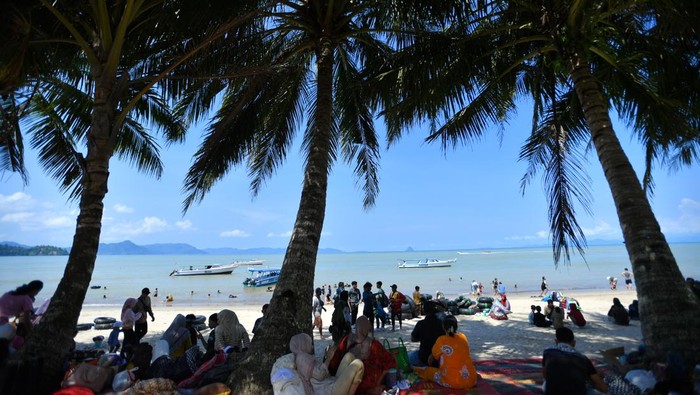 Wisatawan menikmati keindahan pantai saat libur Lebaran 1447 Hijriah di Pantai Pandan, Kabupaten Tapanuli Tengah, Sumatera Utara, Minggu (22/3/2026). Objek wisata Pantai Pandan Tapanuli Tengah mulai dikunjungi wisata lokal dan mancanegara di tengah upaya pemulihan daerah itu yang terkena bencana longsor dan banjir bandang pada akhir November 2025. ANTARA FOTO/Yudi Manar/nym.