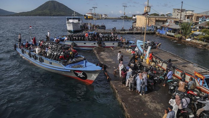 Warga beserta sepeda motornya diangkut dengan perahu kayu bermotor untuk menyeberang ke Tidore di Pelabuhan Bastiong Ternate, Maluku Utara, Minggu (22/3/2026). Pada hari kedua Idul Fitri 1447 Hijriah, Kantor Kesyahbandaran dan Otoritas Pelabuhan (KSOP) Kelas II Ternate menyiapkan 12 unit perahu kayu bermotor selama 24 jam untuk pelayaran rute Ternate-Tidore bagi masyarakat yang ingin bersilaturahim dengan keluarganya. ANTARA FOTO/Andri Saputra/nym.