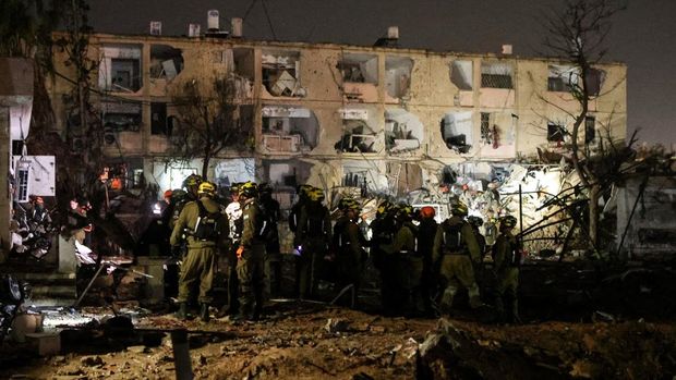 Tentara Israel bekerja di lokasi kerusakan setelah serangan rudal Iran menghantam Dimona, di tengah konflik AS-Israel dengan Iran, di Israel selatan, 21 Maret 2026. (REUTERS/Ilan Assayag)