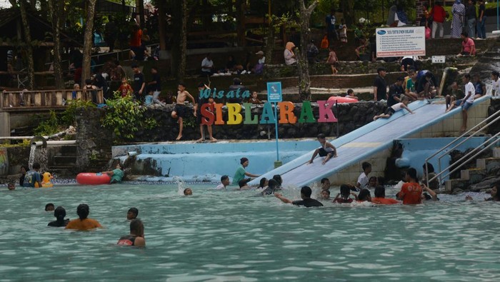 Pengunjung bermain air di kolam Umbul Siblarak, Sidowayah, Polanharjo, Klaten, Jawa Tengah, Minggu (22/3/2026). Data pengurus wisata Umbul Siblarak menyebutkan, kunjungan wisata air pada masa libur Lebaran 2026 per Sabtu (21/3) mencapai 1.000 pengunjung, atau naik dibanding hari normal biasa sebanyak 800 pengunjung dan menargetkan kunjungan hingga tanggal (29/3) mencapai 20 ribu orang. ANTARA FOTO/Aloysius Jarot Nugroho/wsj.