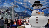 Keluarga pengunjung mengabadikan momen di spot foto Little Mountain dengan ikon manusia salju di Trans Snow World Surabaya saat libur Lebaran 2026.