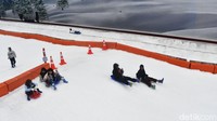 Anak-anak bermain seluncuran salju di area wahana Trans Snow World Surabaya. Area salju menjadi daya tarik utama yang paling diminati pengunjung saat libur Idul Fitri.