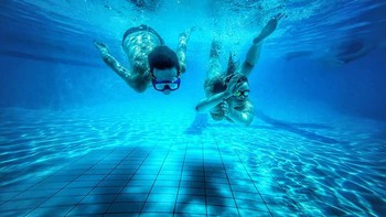 Pemenang kategori People diraih Louise Rayner. Dua perenang meluncur di bawah air dalam harmoni sempurna, dibingkai oleh riak cahaya dan garis-garis kolam yang geometris. Komposisi ini menyeimbangkan simetri dan gerakan, sementara nuansa biru menciptakan kedalaman yang tenang. Louise Rayner dengan terampil menggunakan kamera ponsel untuk menangkap koneksi manusia yang menyenangkan dan mendalam. Foto: Mobile Photography Awards