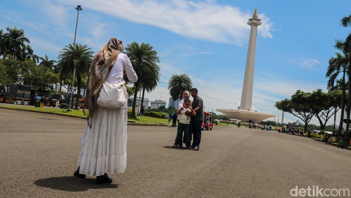 Anak-anak bermain dan berlarian di kawasan Monumen Nasional, Senin (23/3/2026). Suasana H+2 Lebaran dimanfaatkan warga untuk berwisata dan menikmati ruang terbuka di pusat ibu kota.
