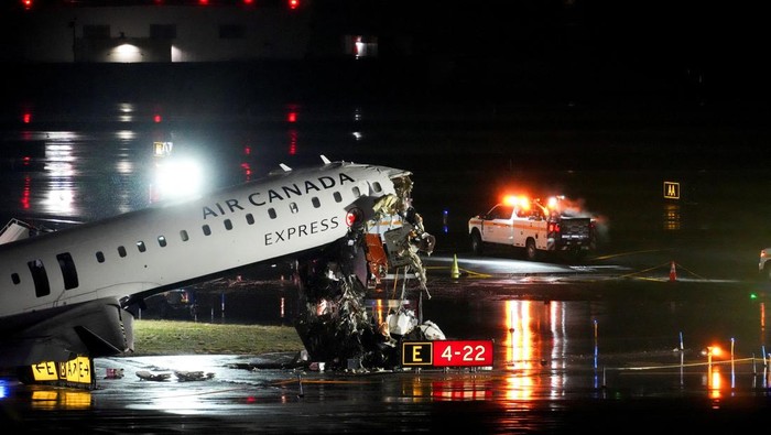 Debris hangs from a damaged Air Canada Express jet that had collided with a fire truck at New Yorks LaGuardia Airport in Queens, New York, U.S., March 23, 2026.  REUTERS/Adam Gray