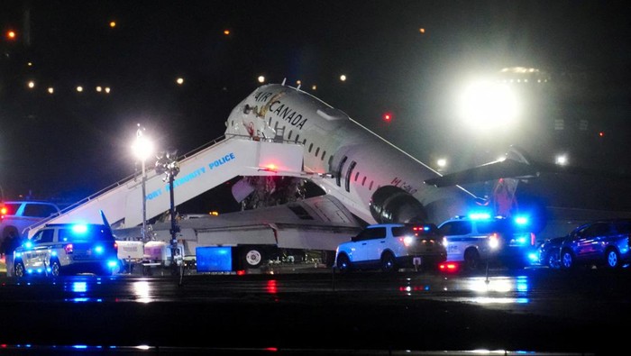 Debris hangs from a damaged Air Canada Express jet that had collided with a fire truck at New Yorks LaGuardia Airport in Queens, New York, U.S., March 23, 2026.  REUTERS/Adam Gray