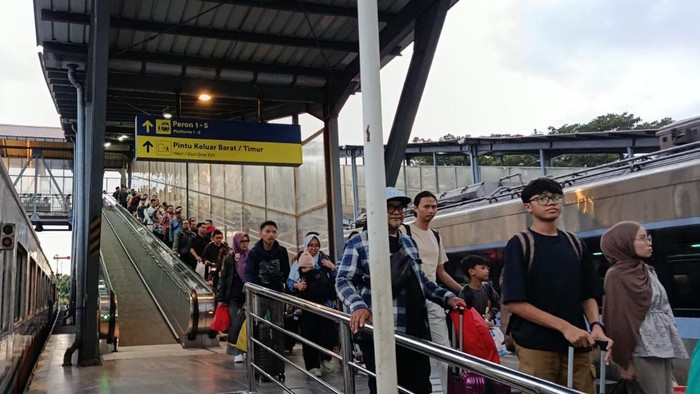 Penumpang yang mengantre masuk ke kereta api di stasiun Malang