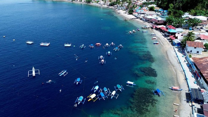 Foto udara pengunjung menaiki perahu wisata untuk melihat hiu paus (Rhincodon Typus) di Pantai Botubarani, Kabupaten Bone Bolango, Gorontalo, Senin (23/3/2026).  Kelompok sadar wisata (Pokdarwis) setempat mencatat lonjakan pengunjung di objek wisata hiu paus sejak H-3 Lebaran dengan rata-rata 700 orang/hari yang didominasi wisatawan dari Sulawesi Utara. ANTARA FOTO/Adiwinata Solihin/rwa.