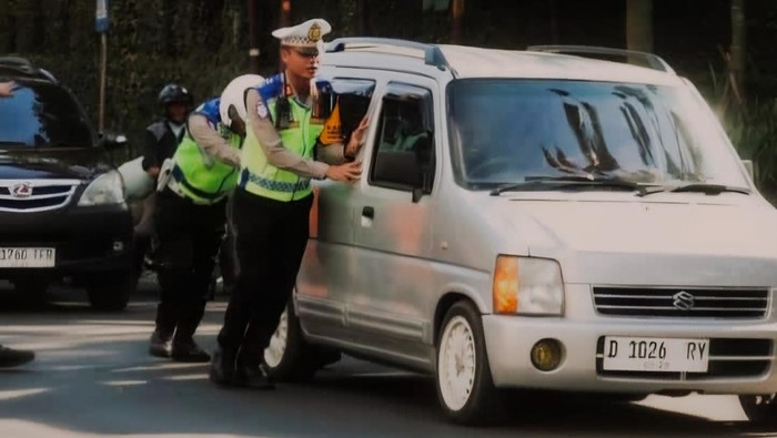 Kasatlantas Polres Cimahi, AKP Arviandre mendorong kendaraan mogok di Lembang