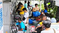 Warga memasukkan pakaian kotor ke dalam mesin cuci di Evi Laundry, Jakarta, Selasa (24/3/2026).