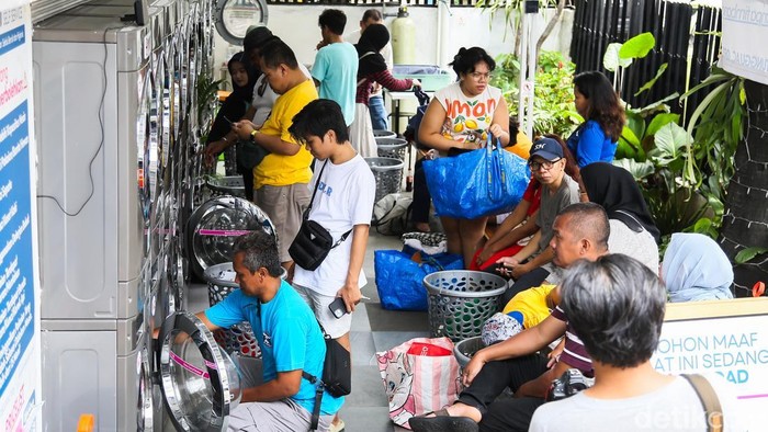 Warga memasukkan pakaian kotor ke dalam mesin cuci di Evi Laundry, Jakarta, Selasa (24/3/2026). Permintaan jasa laundry mengalami lonjakan selama masa libur Lebaran.