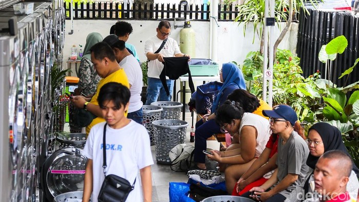 Warga memasukkan pakaian kotor ke dalam mesin cuci di Evi Laundry, Jakarta, Selasa (24/3/2026). Permintaan jasa laundry mengalami lonjakan selama masa libur Lebaran.