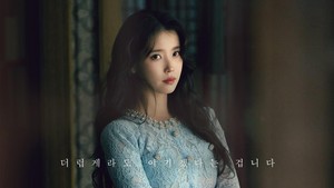 Terbaru, MBC merilis poster IU sebagai Seong Hee Ju. Dia tampil dengan rambut panjang ditata bergelombang dan tergerai, mengenakan dress berpayet warna biru muda. (Foto: dok. MBC)