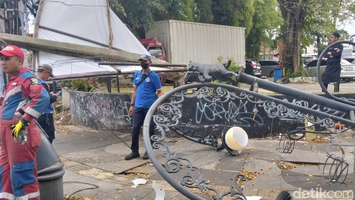 Petugas saat mengevakuasi tiang PJU roboh di dekat Taman Pramuka Bandung.
