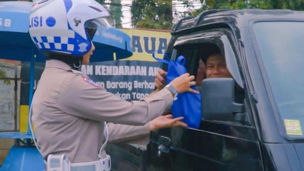 Polwan Satlantas Polres Cimahi membagikan paket makanan ringan ke pemudik
