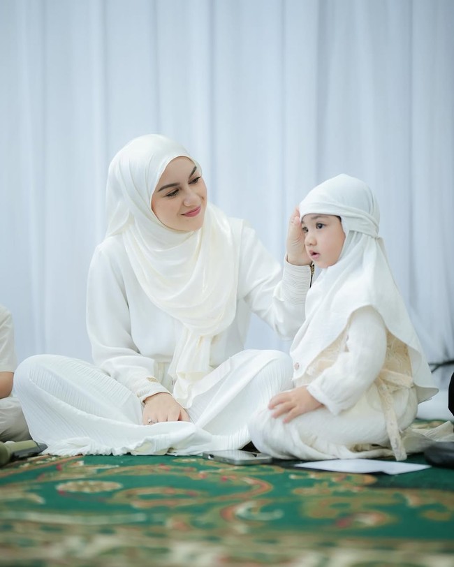 Amala Puti Sabai Akbar, putri dari Irish Bella, tampil dalam balutan busana serta hijab serba putih yang senada dengan ibunda. Foto: Dok. Instagram @_irishbella_.