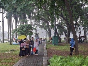 Gerimis Tak Halangi Warga Bekasi-Pekalongan Liburan ke Monas