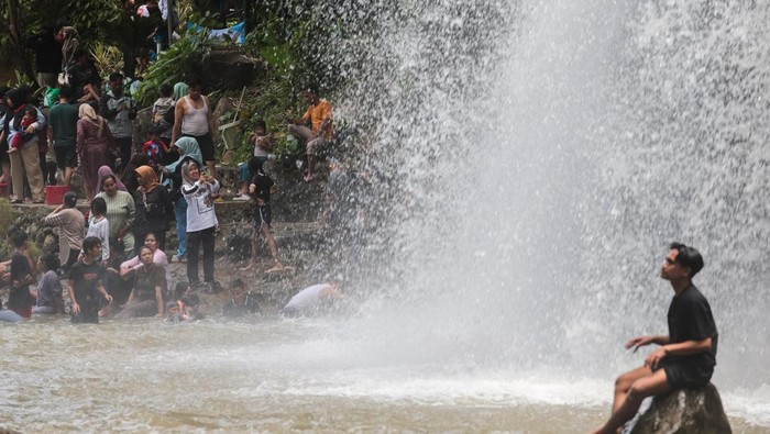 Wisatawan bermain air di sekitar air terjun di Pesona Curug Goong, Mandalawangi, Pandeglang, Banten, Selasa (24/3/2026). Menurut pengelola, jumlah kunjungan ke objek wisata alam yang menawarkan panorama aliran sungai dan air terjun alami tersebut mencapai rata-rata 9.000 orang per hari selama libur Idul Fitri 1447 H atau meningkat lebih dari 50 persen jika dibandingkan hari libur biasa yang didominasi wisatawan asal Tangerang. ANTARA FOTO/Angga Budhiyanto/nym.