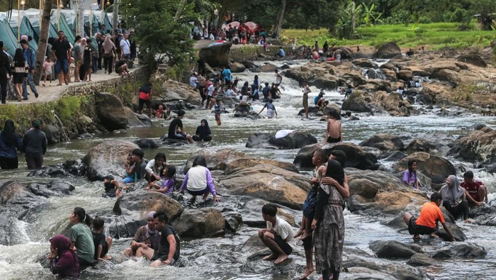 Wisatawan bermain air di sekitar air terjun di Pesona Curug Goong, Mandalawangi, Pandeglang, Banten, Selasa (24/3/2026). Menurut pengelola, jumlah kunjungan ke objek wisata alam yang menawarkan panorama aliran sungai dan air terjun alami tersebut mencapai rata-rata 9.000 orang per hari selama libur Idul Fitri 1447 H atau meningkat lebih dari 50 persen jika dibandingkan hari libur biasa yang didominasi wisatawan asal Tangerang. ANTARA FOTO/Angga Budhiyanto/nym.