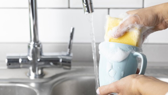 Woman is washing coffee cup.