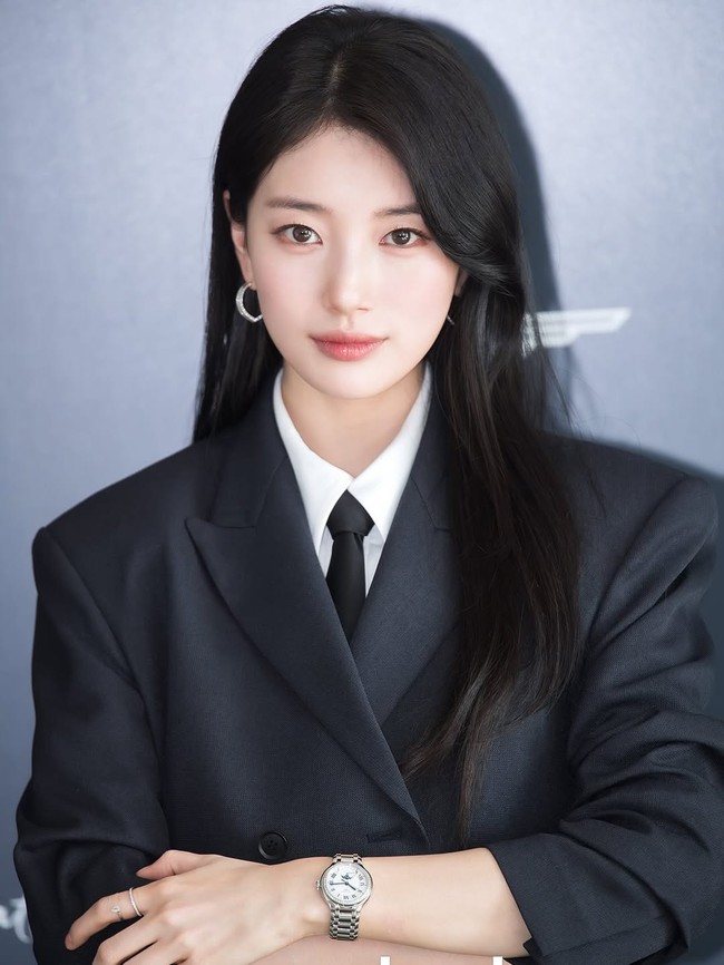 Bintang drakor ‘Genie, Make A Wish’ ini tampil dengan setelan jas oversized navy, lengkap dengan dasi dan aksesori minimalis seperti jam tangan, hoop earing dan cincin di jari telunjuk. Foto: Instagram/@skuukzky