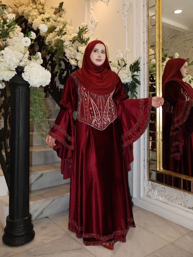 Lebaran hari pertama, wanita yang dikenal sebagai food vlogger ini bergaya glamor dengan gaun merah marun berhias kristal dan payet. Tasyi menampilkan vibe bak princess berkat aksen ruffle dan siluet lonceng pada lengan. Foto: instagram/@tasyiiathasyia