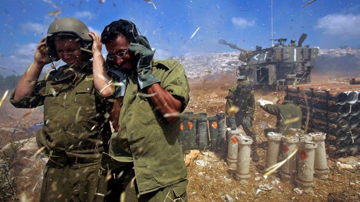 Tentara Israel menutup telinga saat sebuah unit artileri melepaskan tembakan ke Lebanon selatan pada Agustus 2006. (Getty Images)