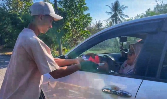 Berbagi semangka untuk pemudik yang terjebak macet.