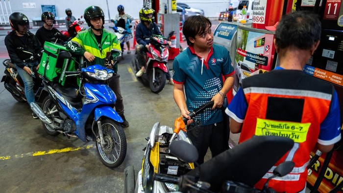 People with vehicles queue to fill up fuel at a gas station amid the U.S.-Israeli conflict with Iran, in Bangkok, Thailand, March 26, 2026. REUTERS/Athit Perawongmetha