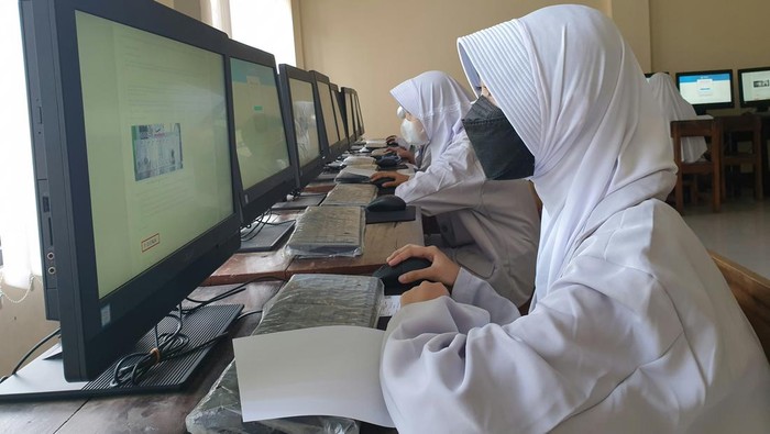 Siswa perempuan menatap layar komputer. Ilustrasi UTBK SNBT.