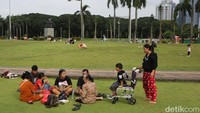Warga menikmati taman kota di kawasan Monumen Nasional (Monas), Jakarta, Kamis (26/3/2026).