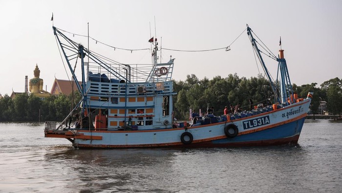 Fishermen transfer a container of catch from a trawler to a truck at a pier, as rising diesel prices have left many trawlers docked due to unprofitable operations, in Samut Sakhon province, Thailand, March 25, 2026, REUTERS/Chalinee Thirasupa