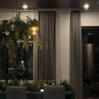 Lampu pencahayaan berwarna kuning menambah kesan hangat pada ruangan. Perpaduan warna coklat pada dinding, kusen, serta tirai jendela menambah suasana alam di dalam rumah Rachel. Foto: Instagram/@ber_bungabungi/@rachelvennya