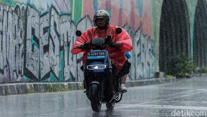 Pesepeda motor menerobos hujan di pedestrian Jalan RE Martadinata, Tangerang Selatan, Jumat (27/3/2026). BMKG memprediksi terjadinya pertumbuhan awan Cumulonimbus (CB) yang mendominasi di sebagian besar wilayah Indonesia dalam sepekan ke depan pada 2