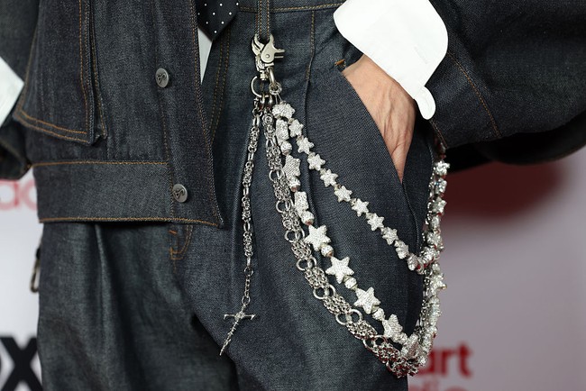 Tak hanya itu, aksen rantai berlapis yang menjuntai di bagian pinggang menjadi focal point yang memperkaya tampilan. Detail ini memberi kesan glam sekaligus rebellious, sejalan dengan estetika streetwear high-fashion yang tengah digemari. (Foto: Frazer Harrison/Getty Images)
