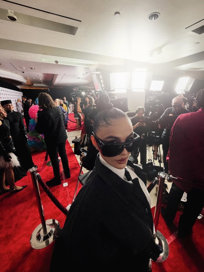 Untuk melengkapi penampilannya, pelantun Coke Bottle ini memilih aksesori minimalis tapi impactful. Kacamata hitam berukuran besar menjadi statement piece yang langsung menarik perhatian, sementara rambutnya ditata sleek dengan gaya top knot yang rapi. (Foto: Instagram/@agnezmo)