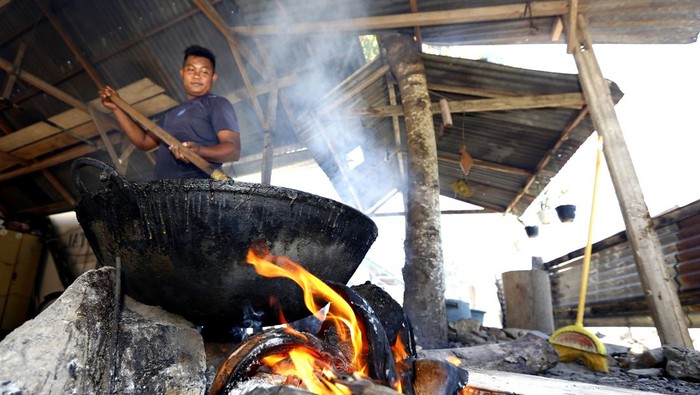 Warga mengaduk dodol yang dimasak menggunakan kuali besar dengan bahan bakar kayu dan sabut kelapa di Desa Yosonegoro, Kabupaten Gorontalo, Gorontalo, Kamis (26/3/2026). Warga keturunan Jawa Tondano (Jaton) mulai memasak dodol yang menjadi kudapan khas Lebaran Ketupat untuk dibagikan kepada setiap tamu yang datang berkunjung pada Sabtu (28/3) nanti. ANTARA FOTO/Adiwinata Solihin/YU