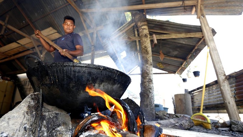 Warga mengaduk dodol yang dimasak menggunakan kuali besar dengan bahan bakar kayu dan sabut kelapa di Desa Yosonegoro, Kabupaten Gorontalo, Gorontalo, Kamis (26/3/2026). Warga keturunan Jawa Tondano (Jaton) mulai memasak dodol yang menjadi kudapan khas Lebaran Ketupat untuk dibagikan kepada setiap tamu yang datang berkunjung pada Sabtu (28/3) nanti. ANTARA FOTO/Adiwinata Solihin/YU