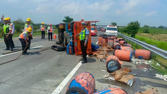 Muatan ikan tumpah di jalan tol usai truk terguling diduga akibat pecah ban.