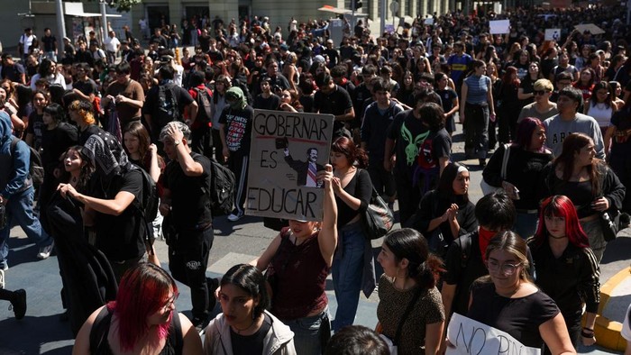 A demonstrator throws an object as a water cannon is used during a protest against the Chilean government's budget cuts to education, in Santiago, Chile, March 26, 2026. REUTERS/Pablo Sanhueza