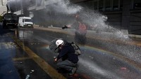  Aparat keamanan menembakkan water cannon untuk membubarkan massa setelah demonstrasi berubah menjadi konfrontasi di pusat kota, saat sebagian demonstran melempar benda ke arah polisi. REUTERS/Pablo Sanhueza