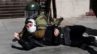 Seorang demonstran diamankan aparat dalam upaya pengendalian massa, di tengah meningkatnya ketegangan selama aksi berlangsung. REUTERS/Pablo Sanhueza