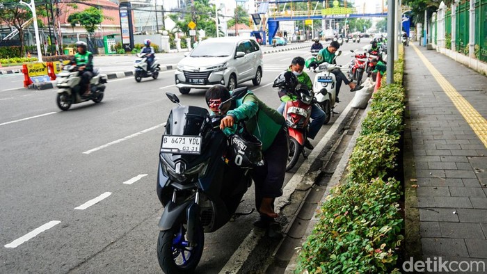 Sejumlah pengemudi ojek online (ojol) menunggu penumpang di depan Stasiun Gambir, Jakarta, Jumat (27/3/2026). Pemerintah berencana menerapkan kebijakan work from home (WFH) selama satu hari dalam sepekan usai Lebaran 2026 sebagai langkah efisiensi bahan bakar.