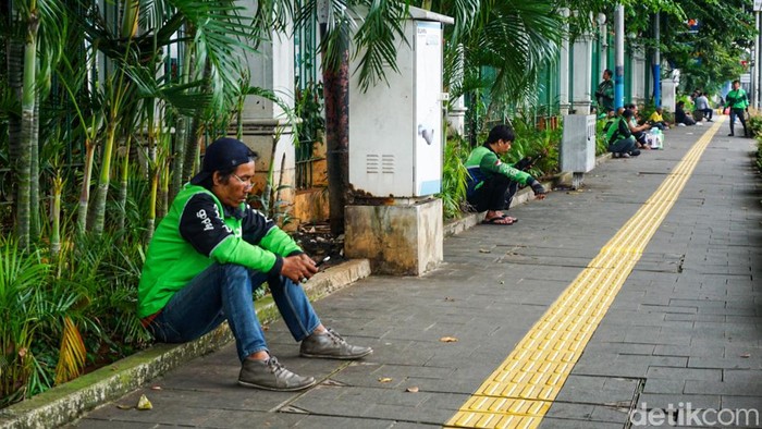 Sejumlah pengemudi ojek online (ojol) menunggu penumpang di depan Stasiun Gambir, Jakarta, Jumat (27/3/2026). Pemerintah berencana menerapkan kebijakan work from home (WFH) selama satu hari dalam sepekan usai Lebaran 2026 sebagai langkah efisiensi ba
