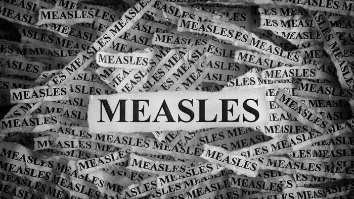 Measles. Torn pieces of paper with the words Measles. Concept image. Black and White. Close up.