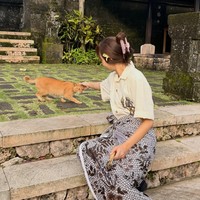 Tak sedikit netizen Indonesia yang heboh menyorot gaya Lisa memakai jarik batik sambil bermain dengan kucing oren. Ia juga menyisipkan bunga melati di telinganya. Foto: dok. Instagram @lalalalisa_m